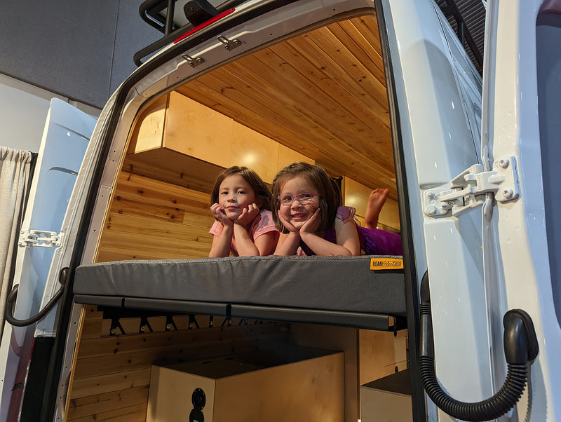 Two girls in van on roamrest mattress