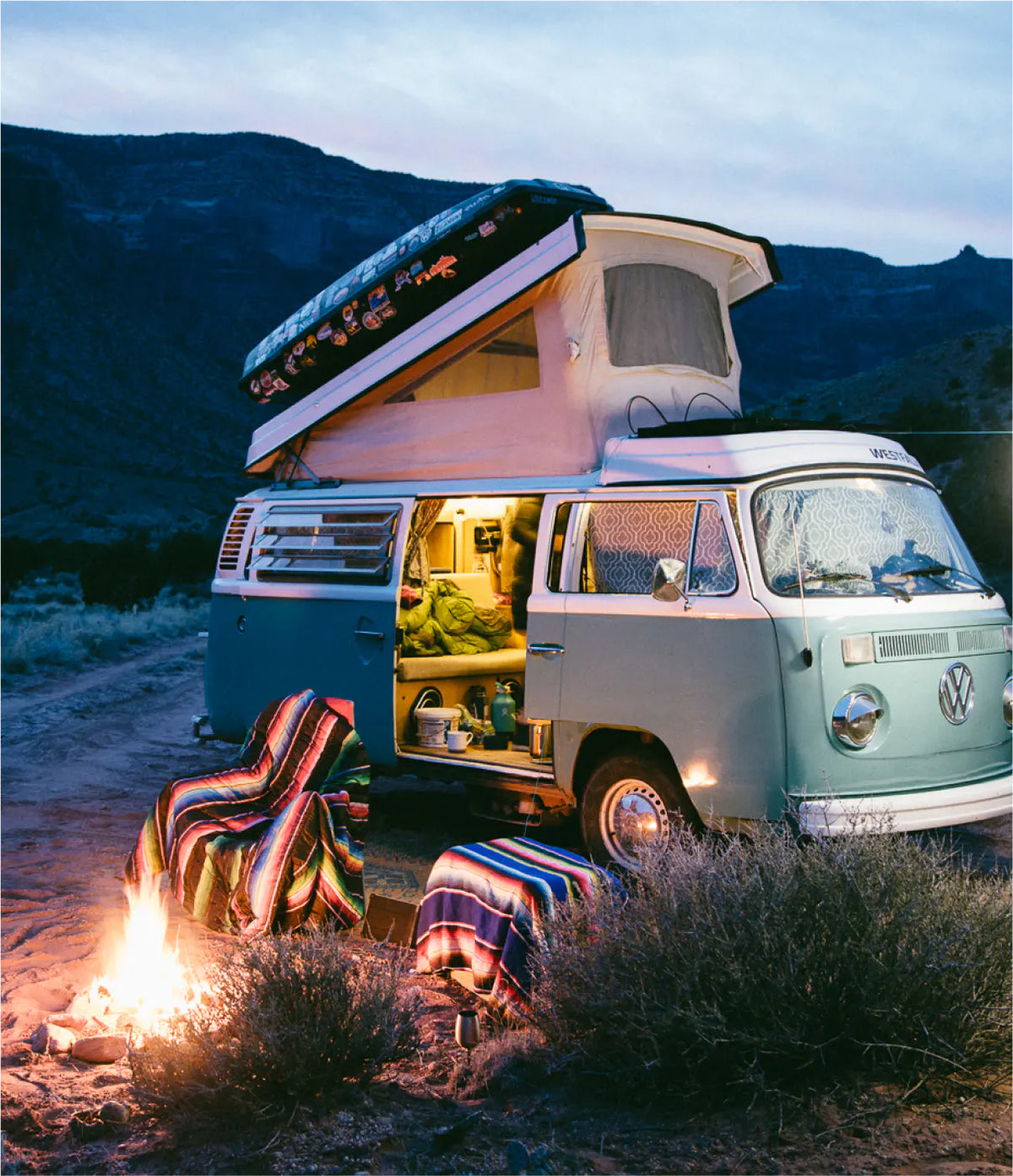 A vintage Volkswagen camper van parked outdoors at dusk