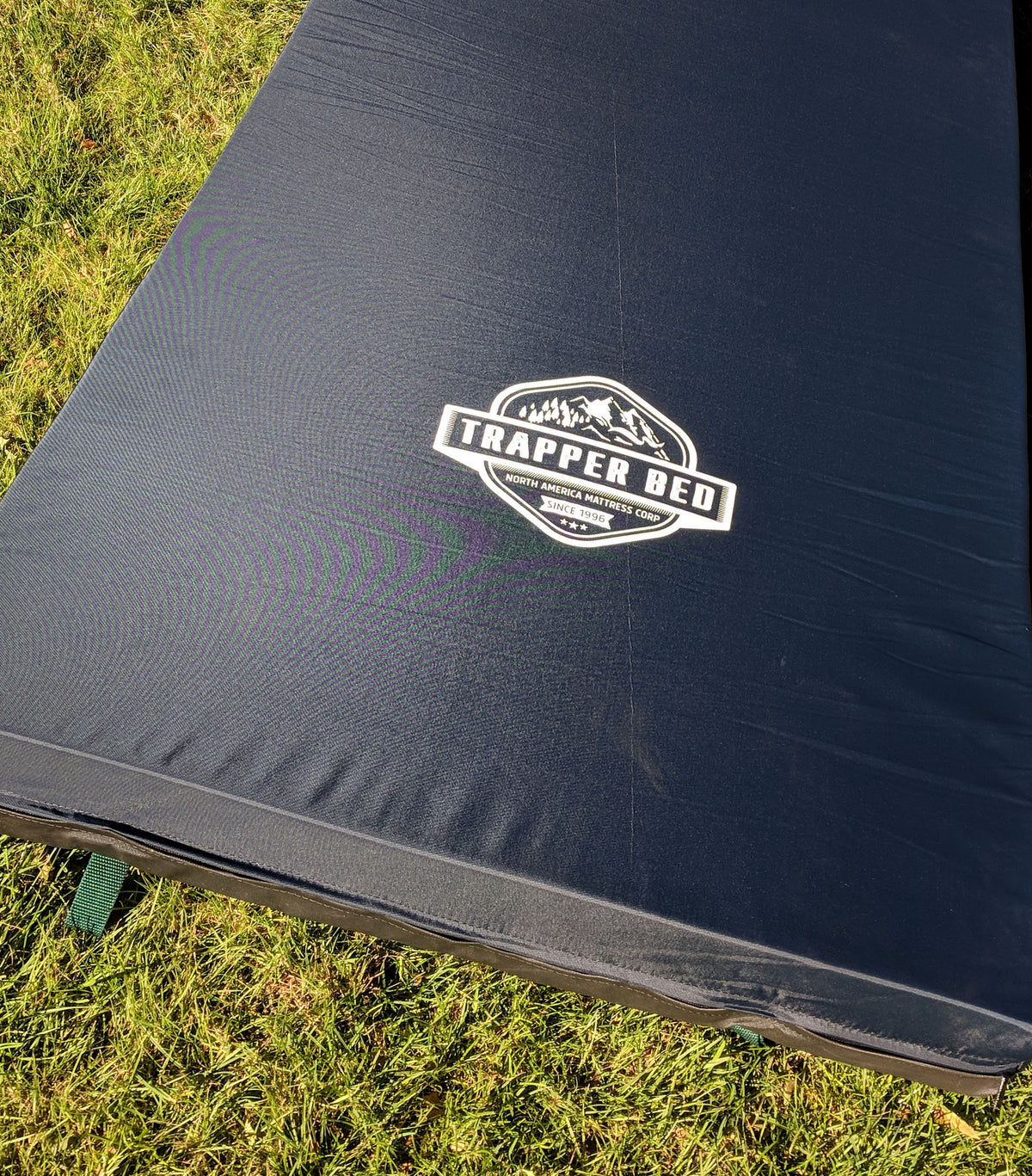 Blue nylon camping mattress on grass